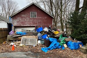 Photo of a house with clutter in front of it