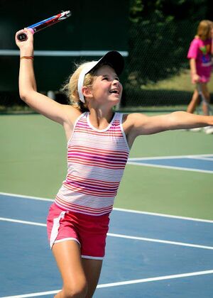Small girl swinging a tennis racket